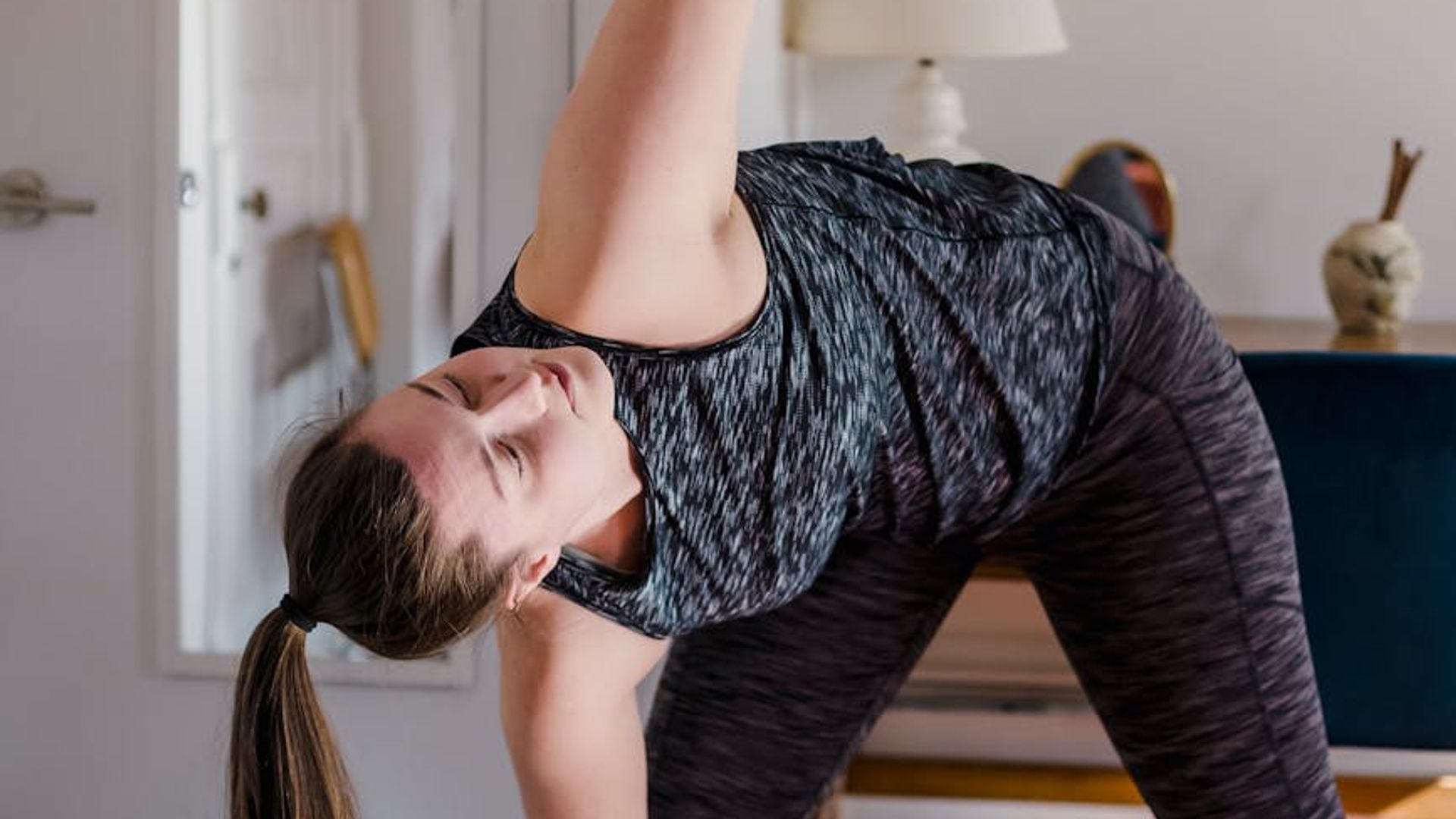 Person practicing yoga in a dark room with neon accents.